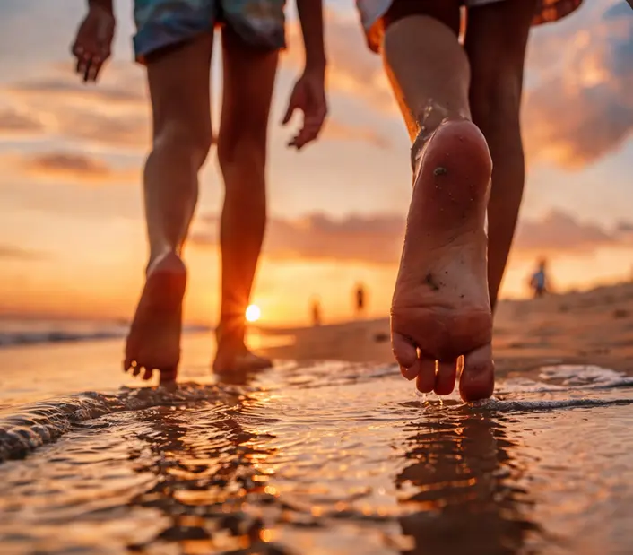 Criança caminhando descalça na areia durante uma experiência de viagem em família